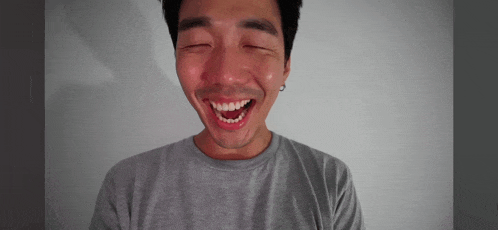 a man with a beard is smiling with his eyes closed and his mouth open