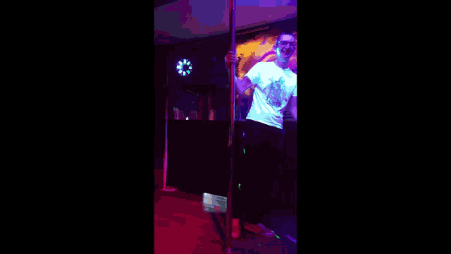 a man stands on a pole in front of a dj