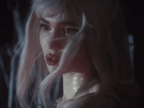 a close up of a woman with white hair and red lips