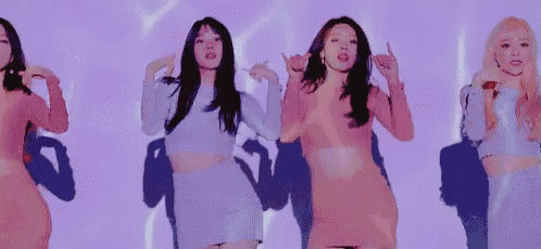 a group of women are standing next to each other and dancing in a room .