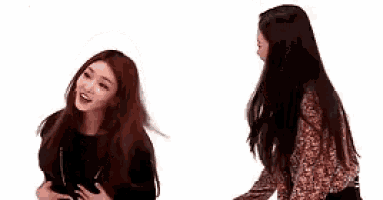 two women are standing next to each other on a white background and talking to each other .