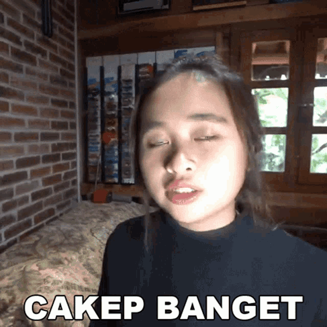 a woman with her eyes closed and the words cakep banget written on the bottom