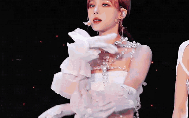 a woman in a white dress with a microphone on her neck