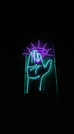 a neon sign with a hand holding a diamond