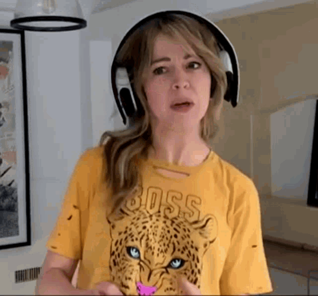 Lindsey Stirling, uma musicista norte-americana, usando fones de ouvido bluetooth e simulando estar jogando videogame.