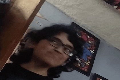 a woman wearing glasses is taking a selfie in a room with a picture on the wall behind her .