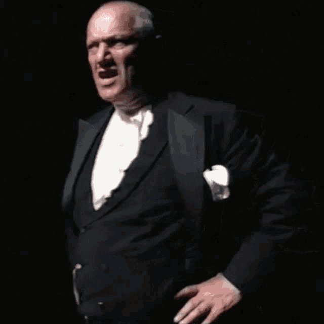 a man in a tuxedo with a white tie and pocket square