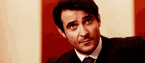 a man in a suit and tie is making a silly face .