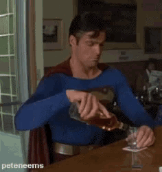a man in a superman costume is pouring a drink