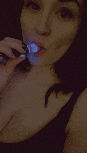 a woman with red lipstick and a nose ring looks at the camera