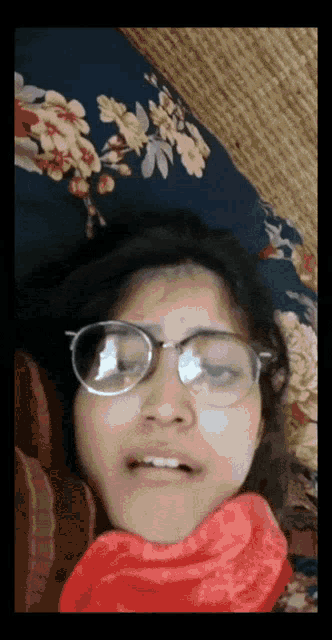 a woman wearing glasses laying on a bed