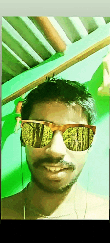 a man with a mustache wearing sunglasses with a green background