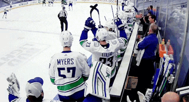 a hockey player with the number 57 on his back is sitting on the bench