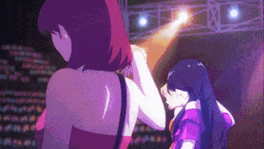 a couple of girls standing on a stage with a light shining on them