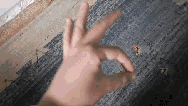 a person 's hand is making an ok sign on a carpet