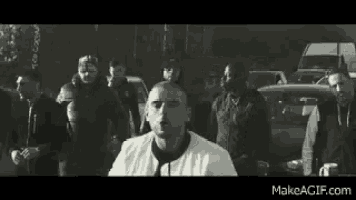 a man in a white shirt and tie is surrounded by a group of men .