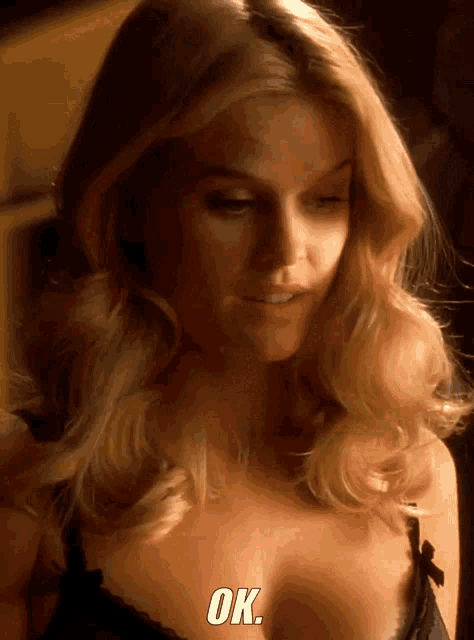 a woman in a black bra says ok on the bottom of her face