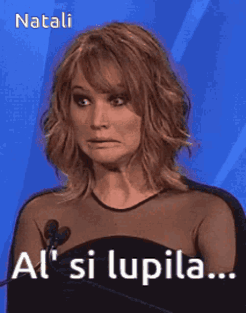 a woman in a black dress stands in front of a microphone and says al ' si lupila