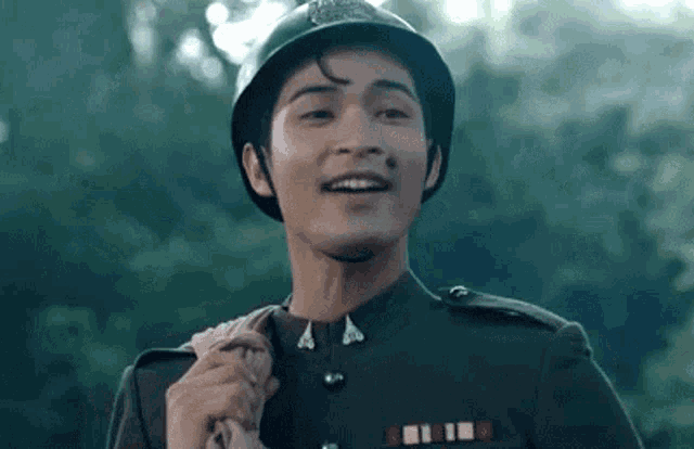 a man in a military uniform and helmet is smiling while holding a rope .