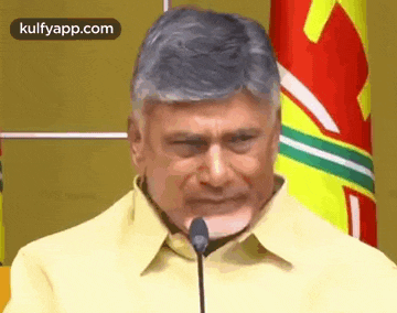 a man is standing in front of a microphone and making a funny face .