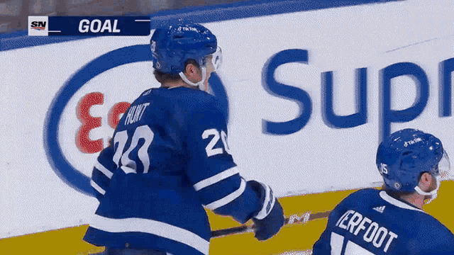 a hockey player with the number 23 on his jersey stands in front of an advertisement for supreme