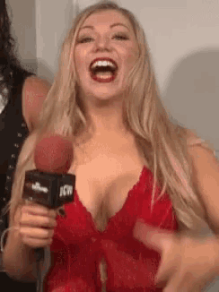 a woman in a red top is holding a microphone that says icw on it