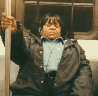 a woman wearing headphones and a black jacket is sitting on a train