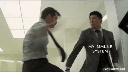 two men in suits and ties are fighting each other in an office .