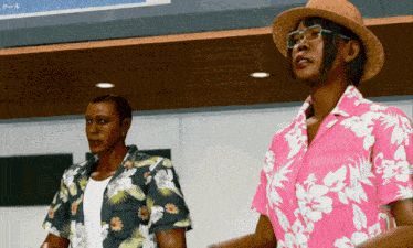 a man and a woman are standing next to each other wearing hawaiian shirts