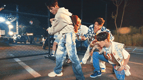 a group of young men are dancing on the street at night