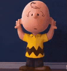 charlie brown from the peanuts movie is standing in front of a blue wall with his hands outstretched .