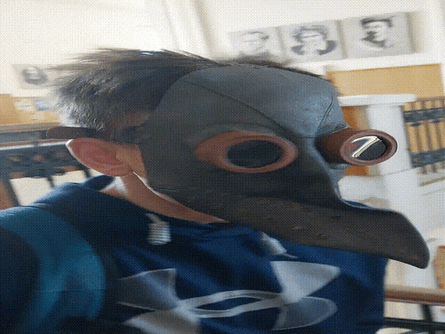 a boy wearing a mask and a under armour sweatshirt