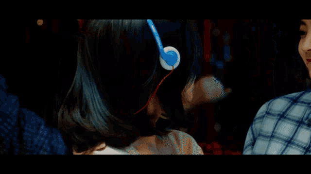 a girl wearing headphones looks at another girl