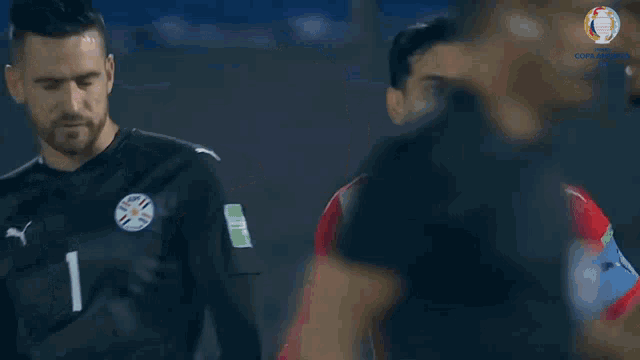 a soccer player with the number 15 on his jersey stands next to another player