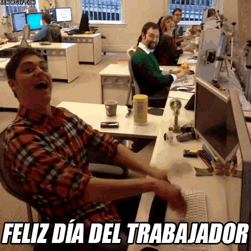 a man sitting at a desk with the words feliz dia del trabajador written below him