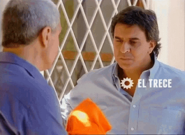 two men are standing next to each other and the word el trece is on the bottom right