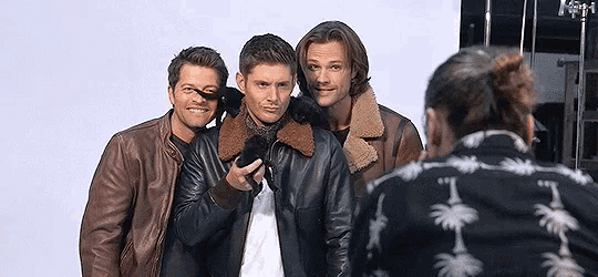 a group of men in leather jackets are posing for a picture .