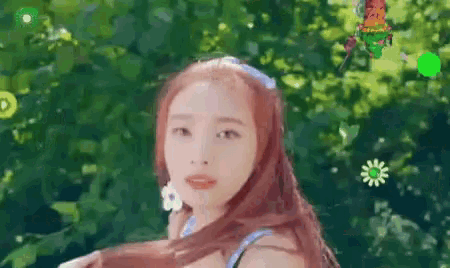a woman with long red hair is standing in front of a green background .