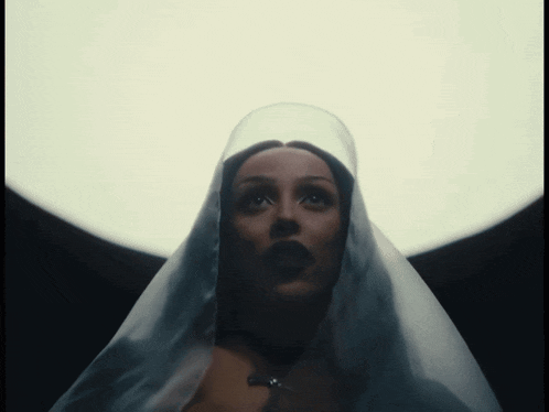 a woman in a white veil is looking up at the sky