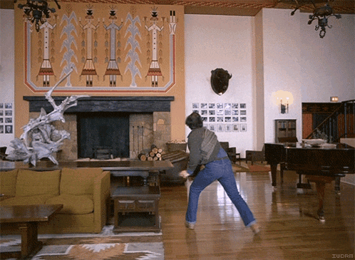 a man is dancing in a living room with the word zucrm written on the bottom