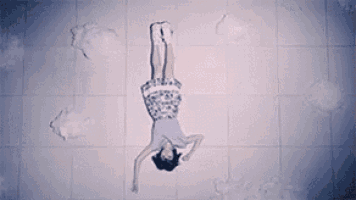 a woman in a dress is doing a handstand on the floor .
