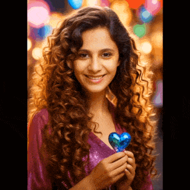 a woman with curly hair is holding a heart shaped lollipop