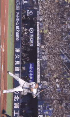 a baseball player swings at a ball in front of a banner that says suntol
