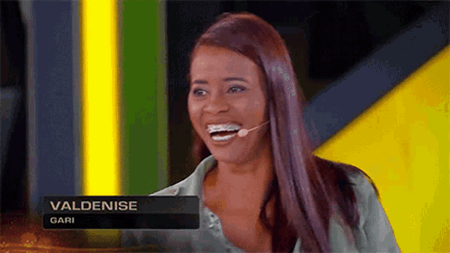 a woman with braces on her teeth is smiling with the name valdenise gari behind her