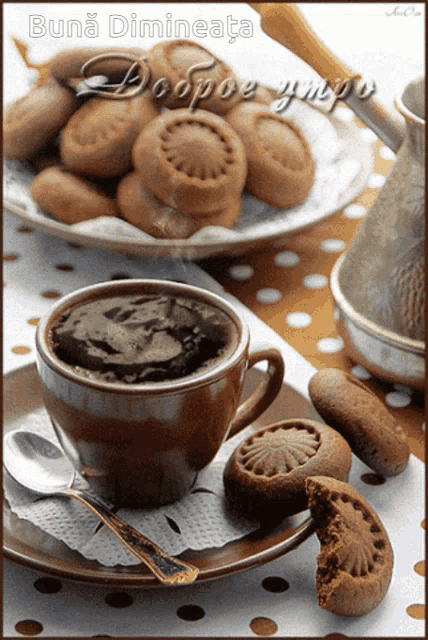 a cup of coffee sits on a saucer next to a plate of cookies and a sign that says buna dimineata