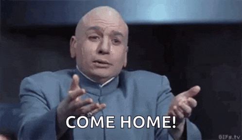 a bald man in a blue suit is making a funny face and saying `` come home '' .