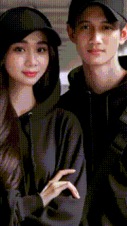a man and a woman standing next to each other wearing black hoodies and hats