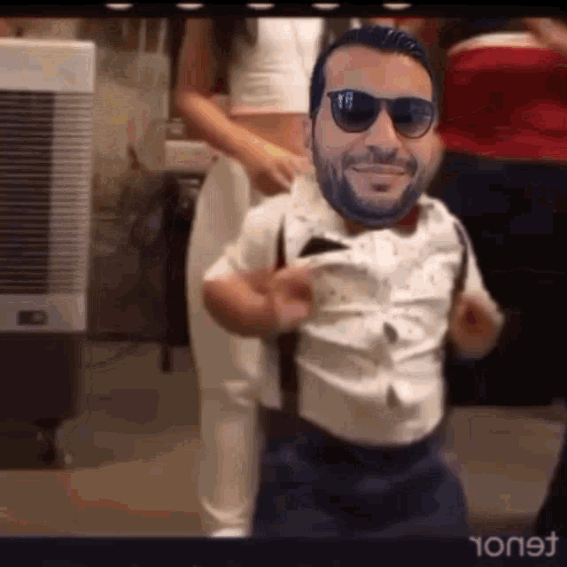 a man wearing sunglasses and suspenders is dancing with a woman in a crop top .