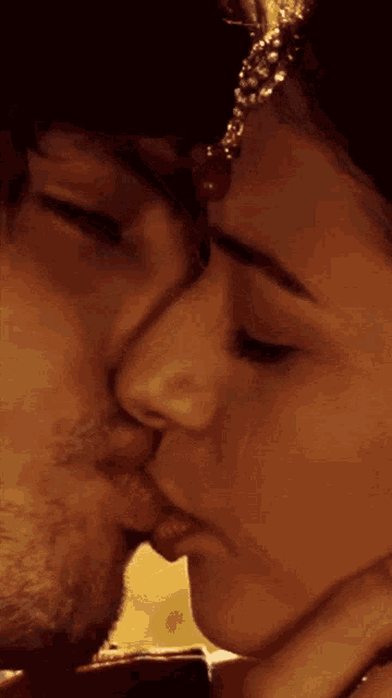 a close up of a man kissing a woman 's cheek