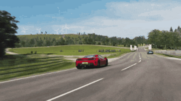a red sports car is driving down a highway